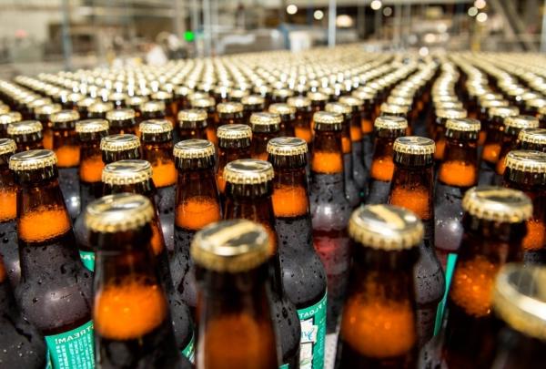 Filled beer bottles on packa杜松子酒g line